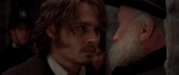 Movie still from “From Hell” (2001), directed by Allen Hughes – A person with a beard and mustache; Close Up shot, Over the shoulder angle