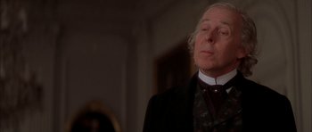 Movie still from “From Hell” (2001), directed by Allen Hughes – An older man wearing a suit and tie; Close Up shot, Low angle