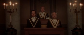 Movie still from “From Hell” (2001), directed by Allen Hughes – A group of three men sitting next to each other in a courtroom; Medium shot, Low angle