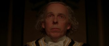 Movie still from “From Hell” (2001), directed by Allen Hughes – A person wearing a suit and bow tie; Close Up shot, Low angle