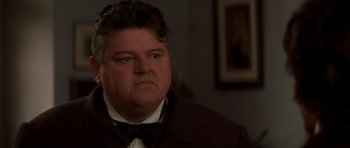 Movie still from “From Hell” (2001), directed by Allen Hughes – A person wearing a suit and bow tie; Close Up shot, Low angle