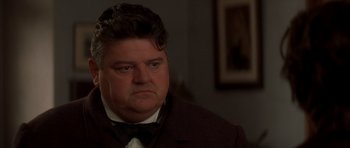 Movie still from “From Hell” (2001), directed by Allen Hughes – A person wearing a suit and bow tie; Close Up shot, Low angle