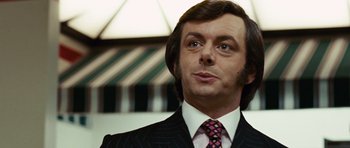 Movie still from “Frost/Nixon” (2008), directed by Ron Howard – A person wearing a suit and tie; Close Up shot, Low angle