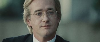 Movie still from “Frost/Nixon” (2008), directed by Ron Howard – A person wearing glasses and a suit; Close Up shot, Over the shoulder angle