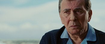 Movie still from “Frost/Nixon” (2008), directed by Ron Howard – An older man in a blue shirt and a black jacket; Close Up shot, Over the shoulder angle