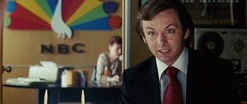 Movie still from “Frost/Nixon” (2008), directed by Ron Howard – A man wearing a suit and tie in front of a mirror; Close Up shot, Over the shoulder angle