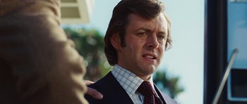 Movie still from “Frost/Nixon” (2008), directed by Ron Howard – A person wearing a suit and tie; Close Up shot, Over the shoulder angle