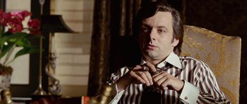 Movie still from “Frost/Nixon” (2008), directed by Ron Howard – A man in striped shirt tying a tie; Close Up shot, Low angle