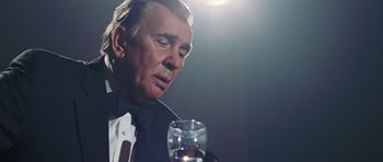 Movie still from “Frost/Nixon” (2008), directed by Ron Howard – An older man in a tuxedo holding a glass of wine; Close Up shot, Low angle