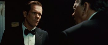 Movie still from “Frost/Nixon” (2008), directed by Ron Howard – A man wearing a suit and tie talking to another man in front of a mirror; Close Up shot, Over the shoulder angle