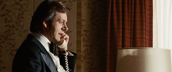 Movie still from “Frost/Nixon” (2008), directed by Ron Howard – A man wearing a suit and tie talking on a phone; Close Up shot, Over the shoulder angle