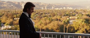 Movie still from “Frost/Nixon” (2008), directed by Ron Howard – A man standing on a balcony looking out at a city; Medium shot, Over the shoulder angle