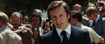 Movie still from “Frost/Nixon” (2008), directed by Ron Howard – A person wearing a suit and tie; Close Up shot, Over the shoulder angle
