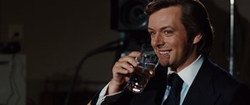 Movie still from “Frost/Nixon” (2008), directed by Ron Howard – A man holding a glass of water in his hand; Close Up shot, Over the shoulder angle