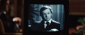 Movie still from “Frost/Nixon” (2008), directed by Ron Howard – A black and white photo of a man wearing a suit and tie; Close Up shot, Over the shoulder angle