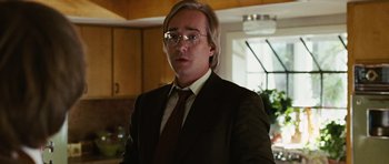 Movie still from “Frost/Nixon” (2008), directed by Ron Howard – A man in a suit and tie standing in front of a counter; Close Up shot, Over the shoulder angle