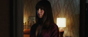 Movie still from “Frost/Nixon” (2008), directed by Ron Howard – A woman with long dark brown hair wearing a purple robe; Close Up shot, Over the shoulder angle