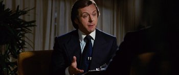 Movie still from “Frost/Nixon” (2008), directed by Ron Howard – A man wearing a suit and tie talking to someone; Close Up shot, Over the shoulder angle