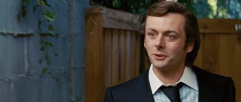 Movie still from “Frost/Nixon” (2008), directed by Ron Howard – A person wearing a suit and tie; Close Up shot, Over the shoulder angle