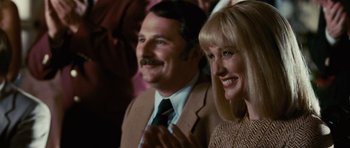 Movie still from “Frost/Nixon” (2008), directed by Ron Howard – A man and a woman are clapping at a party; Close Up shot, Over the shoulder angle