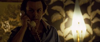 Movie still from “Frost/Nixon” (2008), directed by Ron Howard – A man is talking on a phone in a room; Close Up shot, Low angle