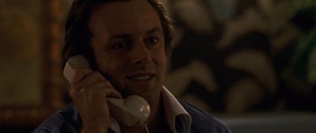 Movie still from “Frost/Nixon” (2008), directed by Ron Howard – A man talking on a phone while sitting down; Close Up shot, Low angle