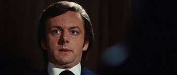 Movie still from “Frost/Nixon” (2008), directed by Ron Howard – A person wearing a suit and tie; Close Up shot, Low angle