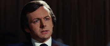 Movie still from “Frost/Nixon” (2008), directed by Ron Howard – A person wearing a suit and tie; Close Up shot, Over the shoulder angle