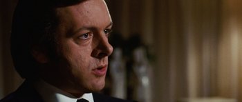 Movie still from “Frost/Nixon” (2008), directed by Ron Howard – A person wearing a suit and tie; Close Up shot, Over the shoulder angle