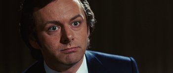 Movie still from “Frost/Nixon” (2008), directed by Ron Howard – A person wearing a suit and tie; Close Up shot, Over the shoulder angle