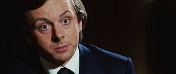 Movie still from “Frost/Nixon” (2008), directed by Ron Howard – A person wearing a suit and tie; Close Up shot, Over the shoulder angle