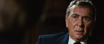 Movie still from “Frost/Nixon” (2008), directed by Ron Howard – An older man wearing a suit and tie sitting down; Close Up shot, Low angle