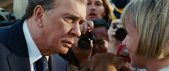 Movie still from “Frost/Nixon” (2008), directed by Ron Howard – A man taking a picture with a camera; Close Up shot, Over the shoulder angle