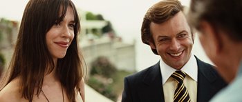 Movie still from “Frost/Nixon” (2008), directed by Ron Howard – A man and a woman posing for a picture; Close Up shot, Over the shoulder angle