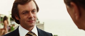 Movie still from “Frost/Nixon” (2008), directed by Ron Howard – A person wearing a suit and tie; Close Up shot, Over the shoulder angle