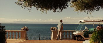 Movie still from “Frost/Nixon” (2008), directed by Ron Howard – A man standing next to the ocean looking at the water; Wide shot, Over the shoulder angle