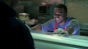 Movie still from “Fruitvale Station” (2013), directed by Ryan Coogler – A man sitting at a counter in a kitchen; Medium shot, Over the shoulder angle