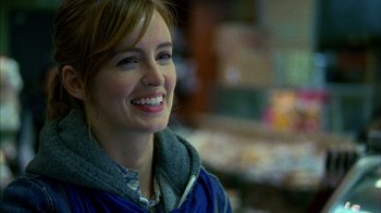 Movie still from “Fruitvale Station” (2013), directed by Ryan Coogler – A woman smiles brightly while wearing a blue jacket; Close Up shot, Over the shoulder angle