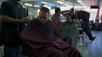 Movie still from “Fruitvale Station” (2013), directed by Ryan Coogler – A man getting his hair cut at a barber shop; Medium shot, Over the shoulder angle