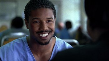 Movie still from “Fruitvale Station” (2013), directed by Ryan Coogler – A person with a smile on his face; Close Up shot, Over the shoulder angle
