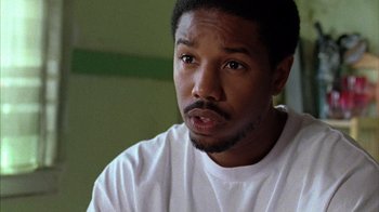 Movie still from “Fruitvale Station” (2013), directed by Ryan Coogler – A person wearing a white t - shirt; Close Up shot, High angle