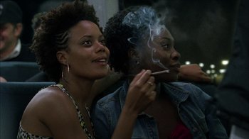 Movie still from “Fruitvale Station” (2013), directed by Ryan Coogler – Two young women are smoking a cigarette together; Close Up shot, Low angle