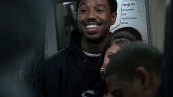 Movie still from “Fruitvale Station” (2013), directed by Ryan Coogler – A man and a woman smile for the camera; Close Up shot, Over the shoulder angle