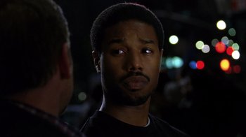 Movie still from “Fruitvale Station” (2013), directed by Ryan Coogler – A person wearing a black t - shirt; Close Up shot, Over the shoulder angle