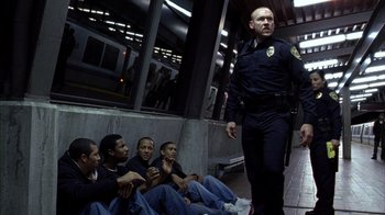 Movie still from “Fruitvale Station” (2013), directed by Ryan Coogler – A police officer talking to a group of people; Wide shot, Low angle