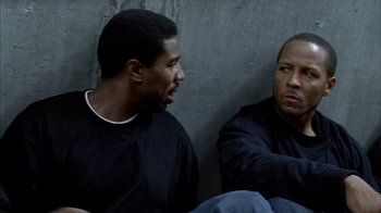 Movie still from “Fruitvale Station” (2013), directed by Ryan Coogler – Two men sitting next to each other on the ground; Close Up shot, High angle