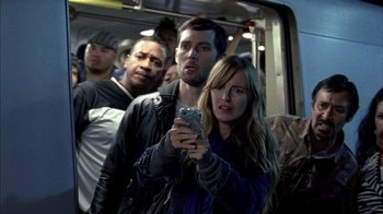 Movie still from “Fruitvale Station” (2013), directed by Ryan Coogler – A woman taking a picture of a group of people on a bus; Medium shot, Low angle