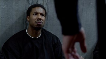 Movie still from “Fruitvale Station” (2013), directed by Ryan Coogler – A man in black shirt looking up at someone; Close Up shot, Over the shoulder angle