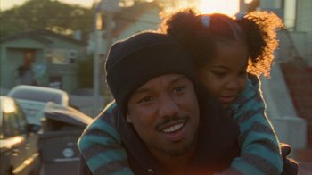 Movie still from “Fruitvale Station” (2013), directed by Ryan Coogler – A man and a girl smiling for the camera; Close Up shot, Over the shoulder angle