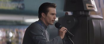 Movie still from “Galaxy Quest” (1999), directed by Dean Parisot – A man is holding a microphone while speaking into a microphone; Close Up shot, Low angle